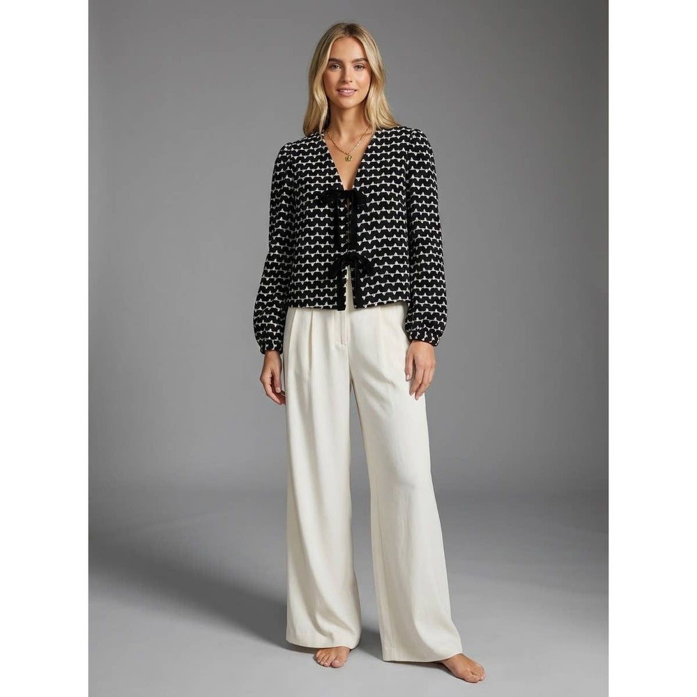 Black and white patterned Muse tie-front blouse with long sleeves and a v-neckline tied with black ribbons at the front