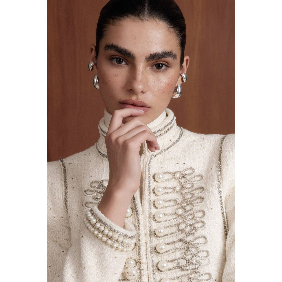 Cream-colored bouclé military jacket with pearl and silver thread embellishments for elegant outerwear