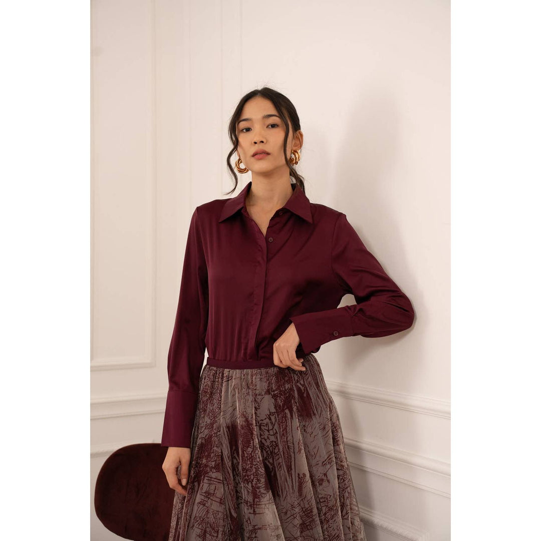 A sleek long-sleeved burgundy satin button-up shirt with classic collar and fitted waist named Lia Satin Shirt-Bordeaux