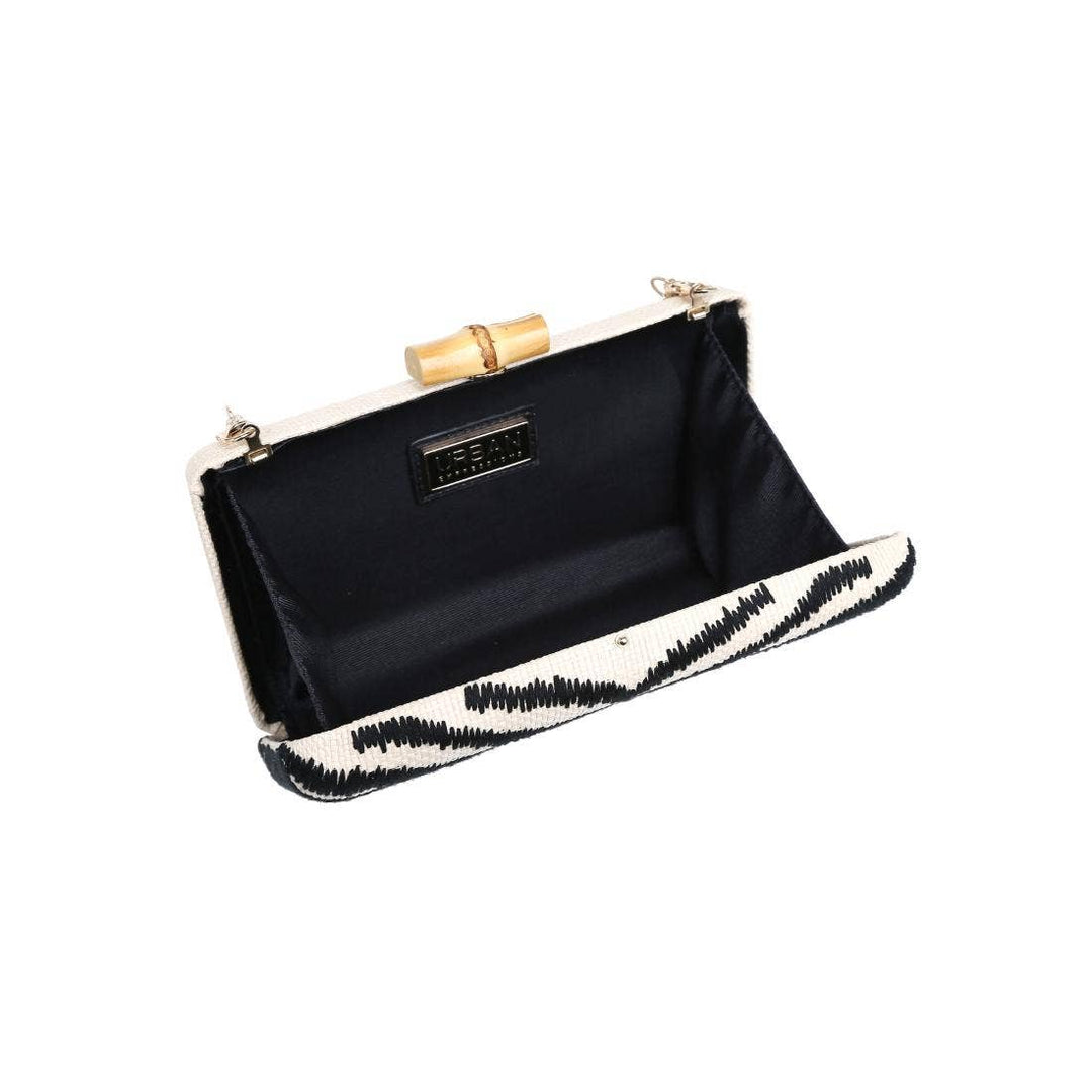 Dorit clutch featuring a black and white zebra stripe pattern with a bamboo handle in a stylish design