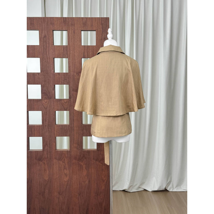 Beige double-breasted cape top with collar and flared sleeves made of linen displayed on mannequin