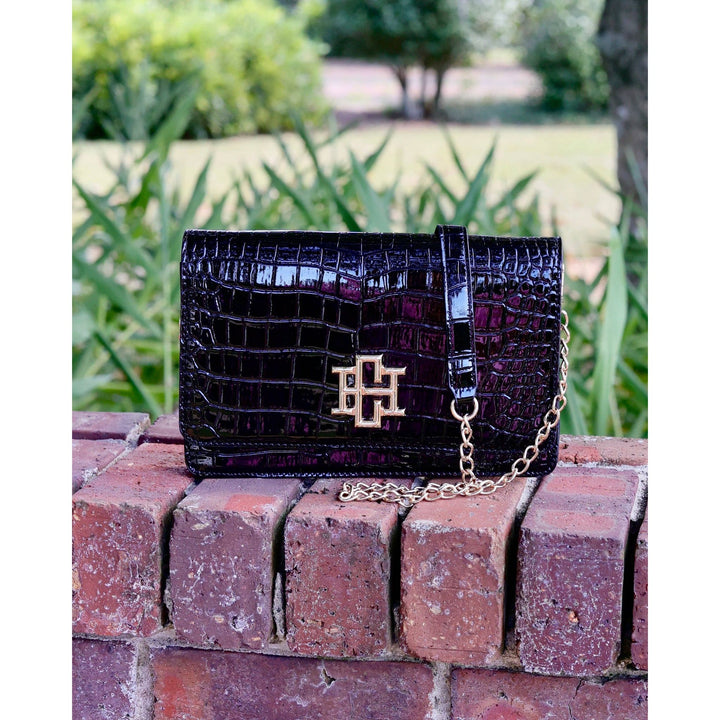 Bryn clutch black patent crocodile-embossed leather with gold-tone logo clasp and chain strap