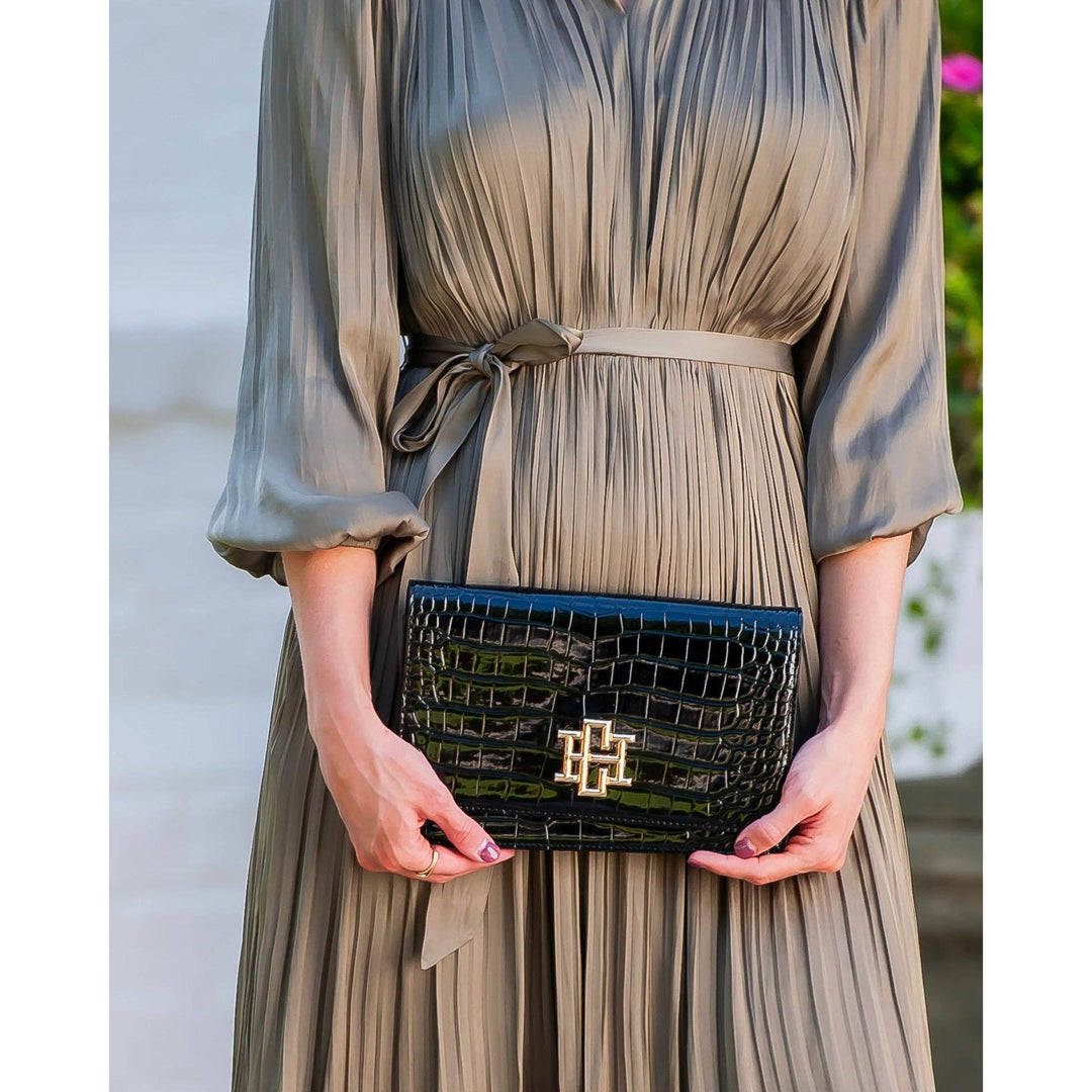 Black patent bryn clutch with crocodile embossing and gold tone logo clasp
