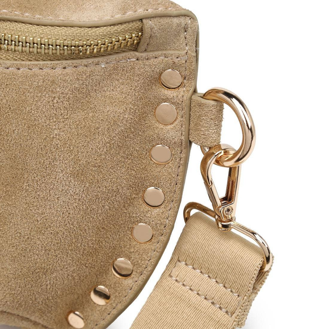 Beige suede crossbody gizelle belt bag with gold-tone studs and adjustable strap bone color