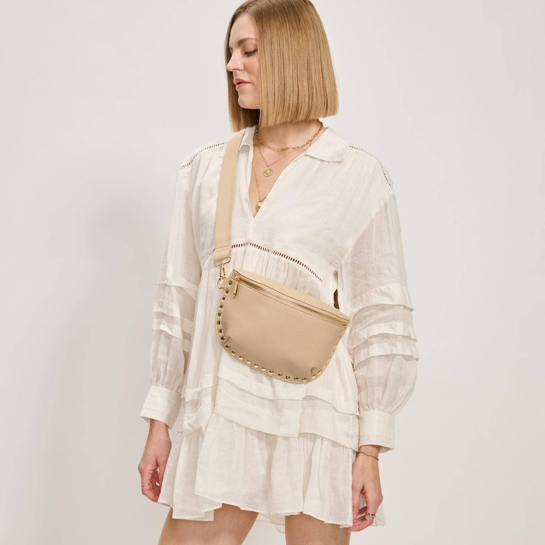 Beige leather gizelle belt bag with gold-tone studs along edge designed as a crossbody belt bag natural color