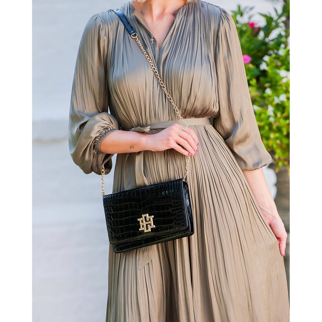Black crocodile-embossed bryn clutch crossbody bag with gold-tone hardware and chain strap in patent leather