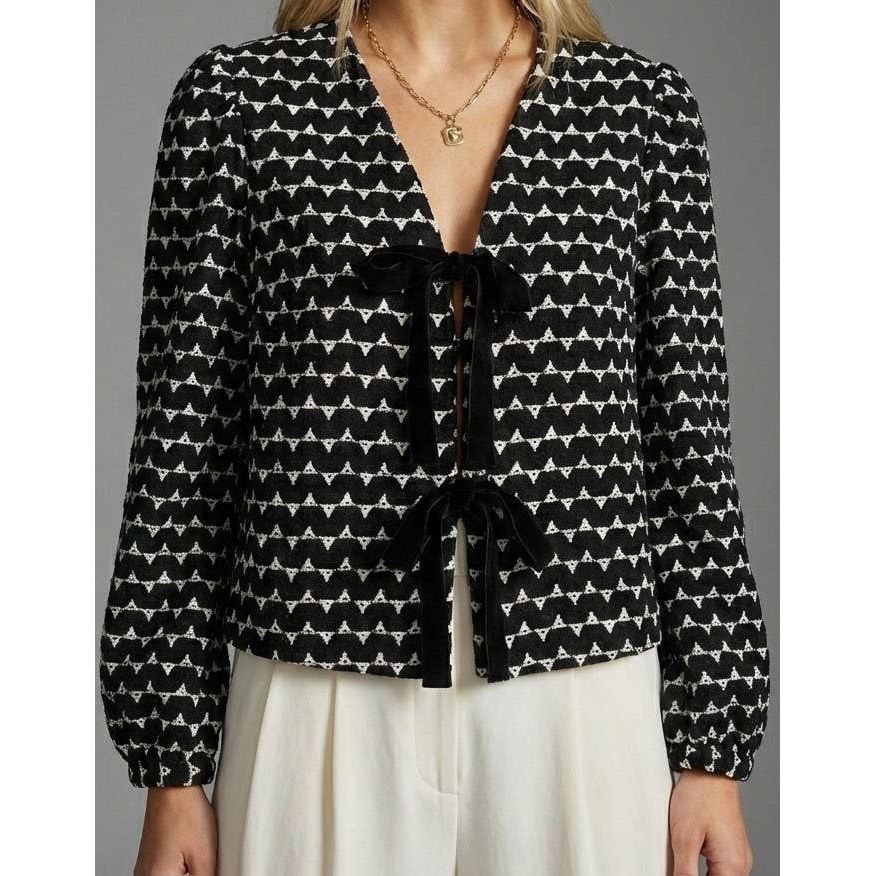 Black and white patterned muse tie-front blouse with v-neck long sleeves and black velvet front ties