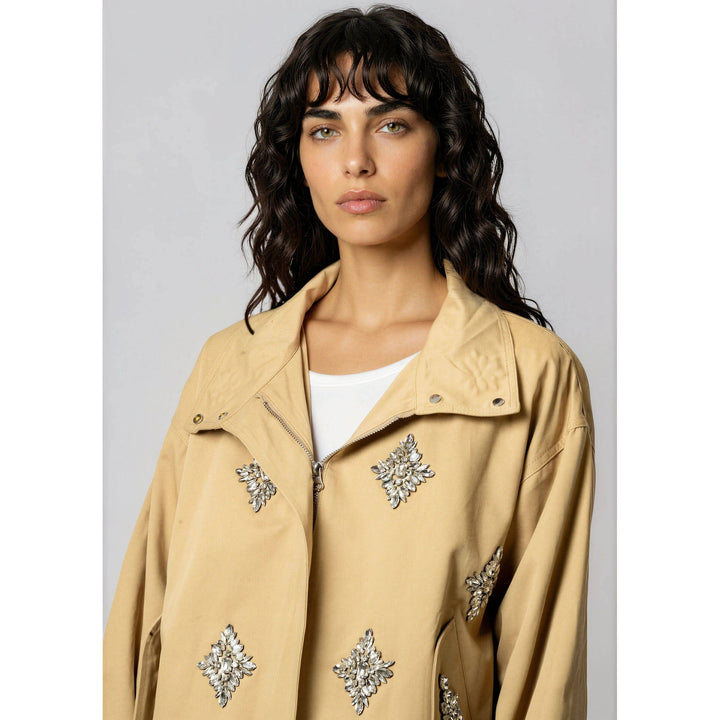 Beige crystal embellished utility jacket with silver leaf shaped embellishments on a trench coat style design