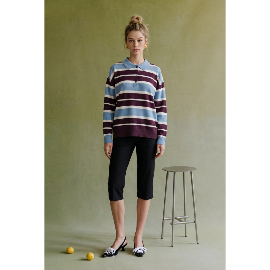 A woman wearing a long-sleeved striped polo sweater with horizontal maroon light blue and white bands