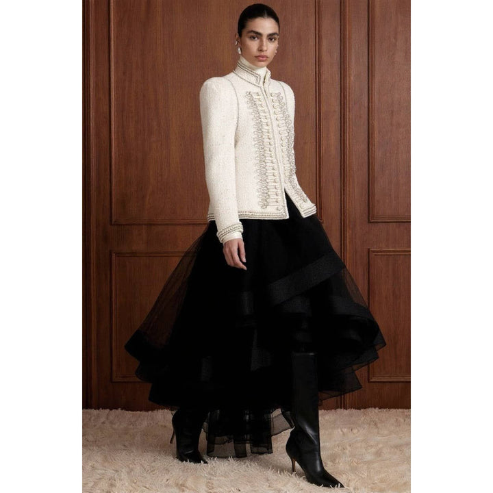 A cream-colored bouclé military jacket with intricate silver embroidery and pearl embellishments on the front and cuffs