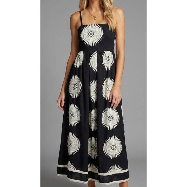 Black lunar bloom maxi dress with white sunburst patterns thin straps and flowing sundress silhouette