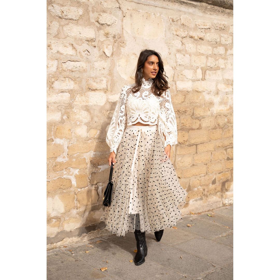 White lace crop top with long sleeves paired with black polka dot aria tulle skirt for a stylish look
