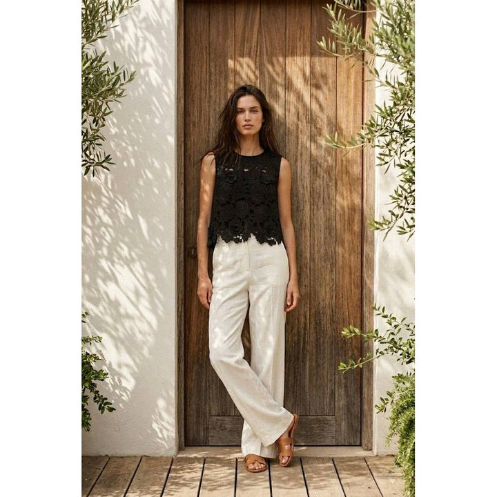 Black lace sleeveless floral applique top with round neckline and scalloped hemline for elegant wear