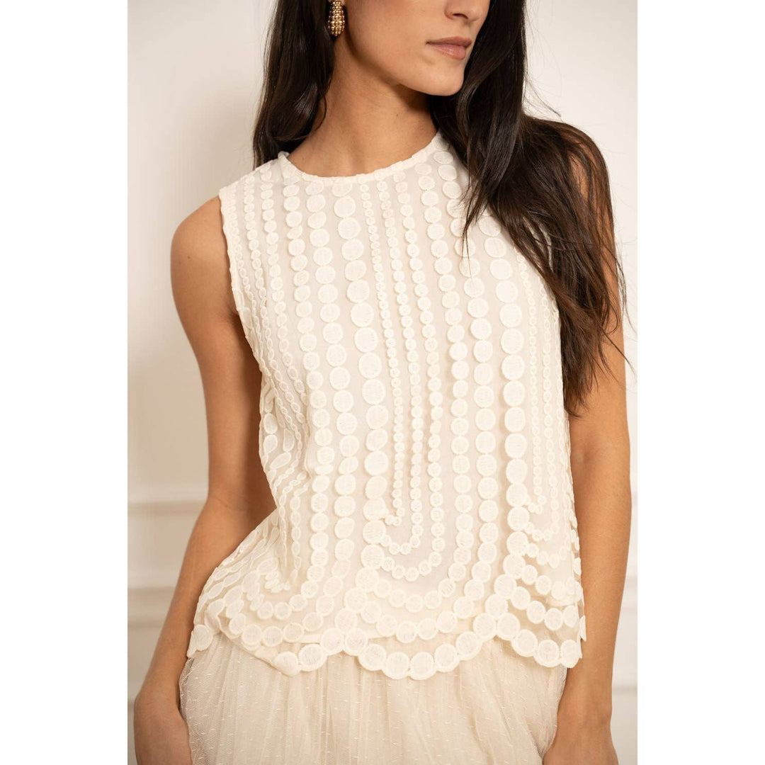 White sleeveless embroidered tulle top with textured circular embellishments and scalloped hem for stylish wear