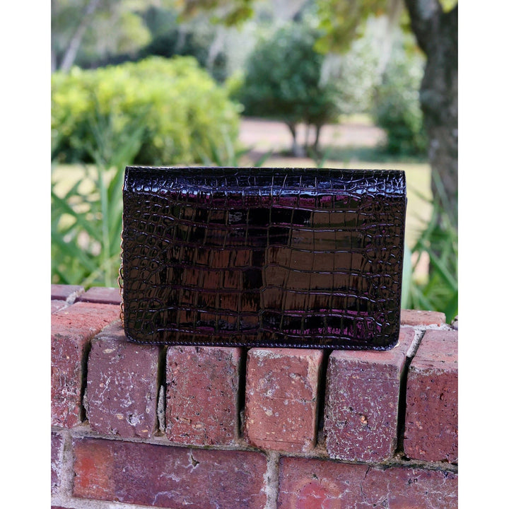 Shiny black patent bryn clutch purse with crocodile pattern in a sleek rectangular design