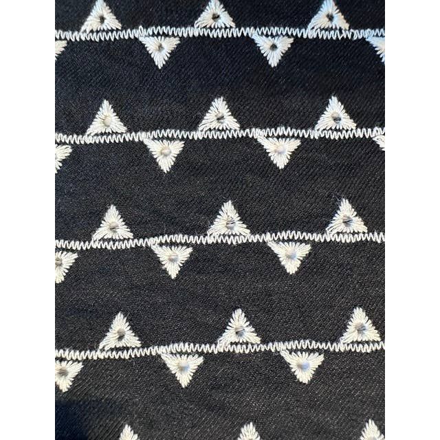 Black muse tie-front blouse featuring white embroidered triangles and zigzag stitching on lightweight fabric