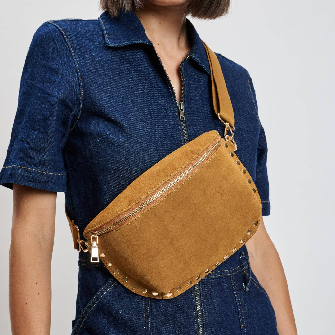 Tan suede gizelle belt bag with gold-tone studs crossbody style and zipper details for hands-free carrying