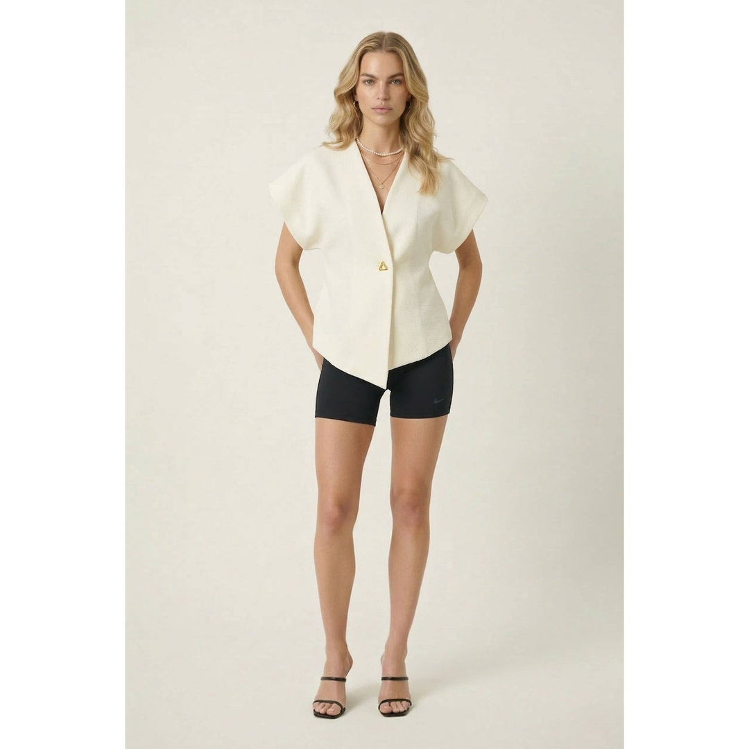 Off-white textured wrap top short-sleeved blouse with asymmetrical hem and gold triangular logo on the left side