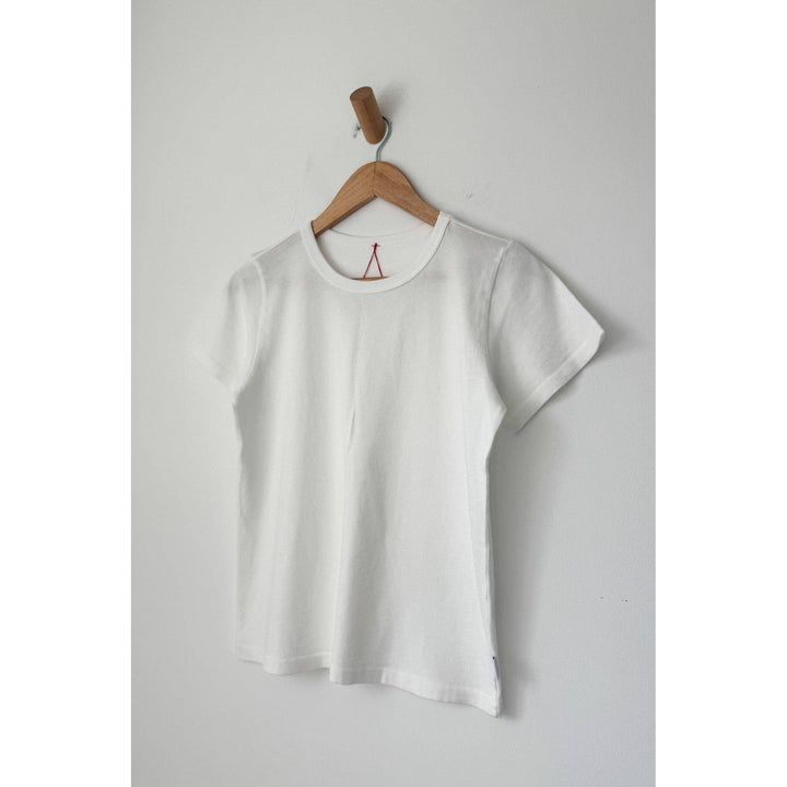 The go-to premium tee white is a white cotton short-sleeved t-shirt with a crew neck and red triangular logo