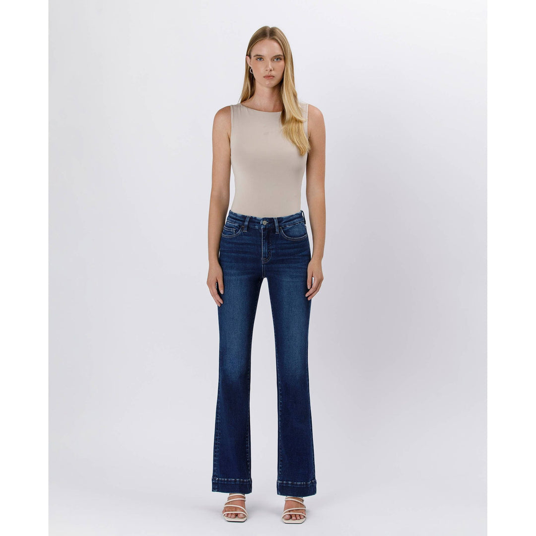 High rise trouser denim featuring dark blue high waisted flared jeans with five pockets and subtle thigh fading
