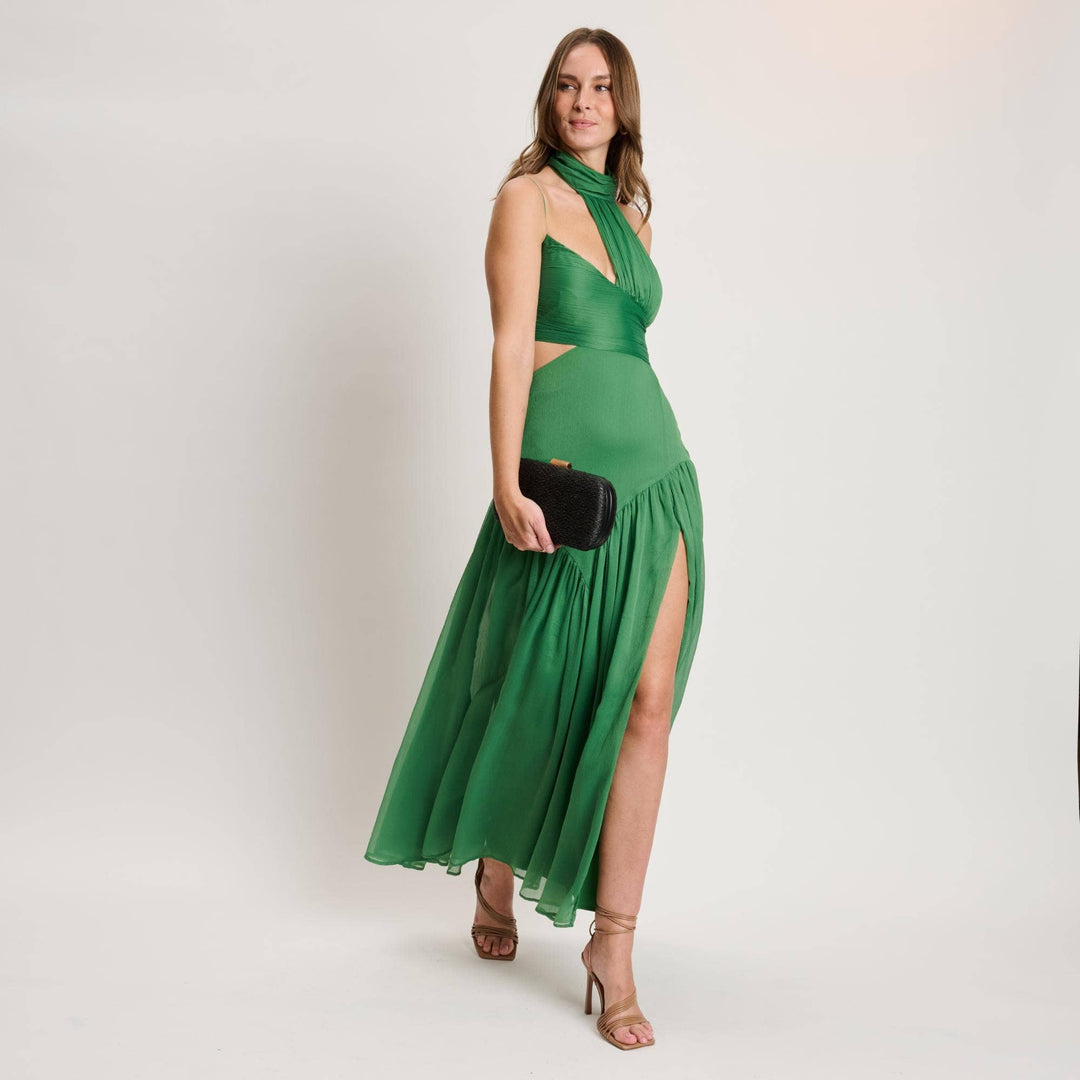 Emerald green halter neck maxi dress with high slit and cut out details paired with quinn evening bag