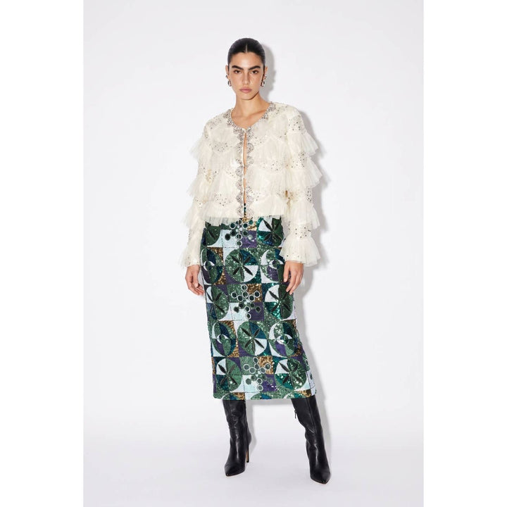 A woman wears a sequin embellished high-waisted midi skirt with an intricate green blue and gold geometric pattern