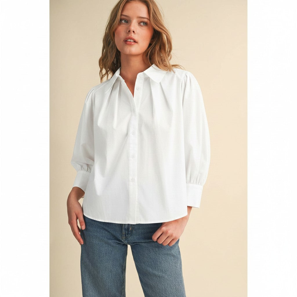 The Pearl Pagoda Camille white cotton buttondown blouse with pleated front, split neckline, and long sleeves.