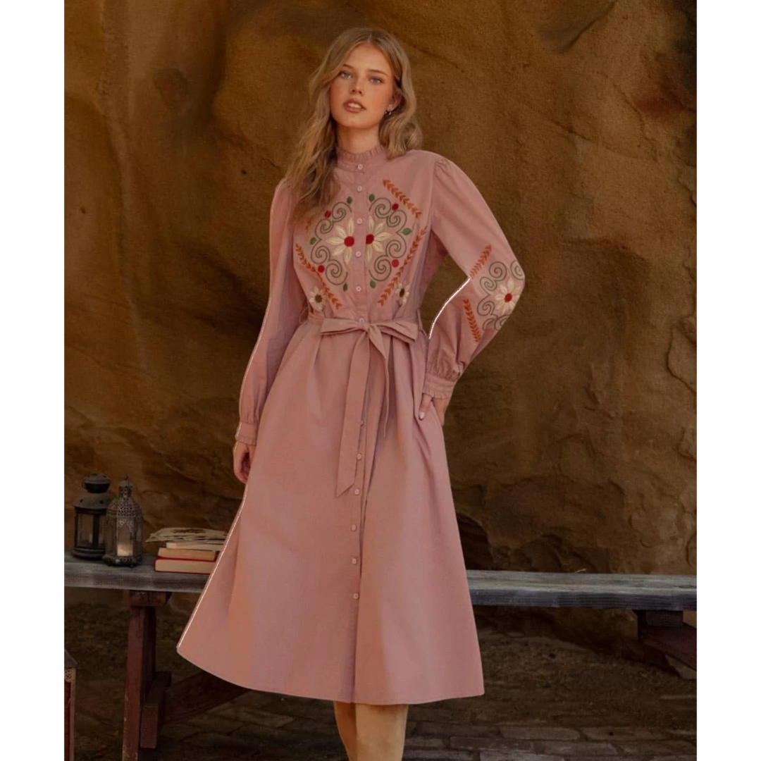 The Pearl Pagoda dusty rose cotton midi shirtdress with floral embroidery, ruffled collar, and tie-waist belt.