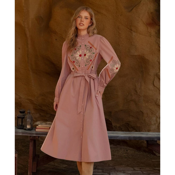 The Pearl Pagoda dusty rose cotton midi shirtdress with floral embroidery, ruffled collar, and tie-waist belt.