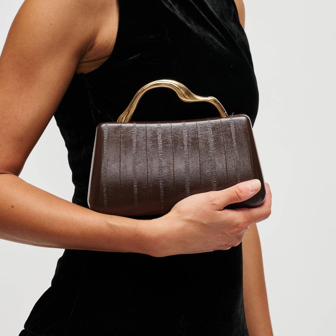The Pearl Pagoda Nichelle clutch in espresso brown with a sculptural gold metal handle and vertical embossed texture.