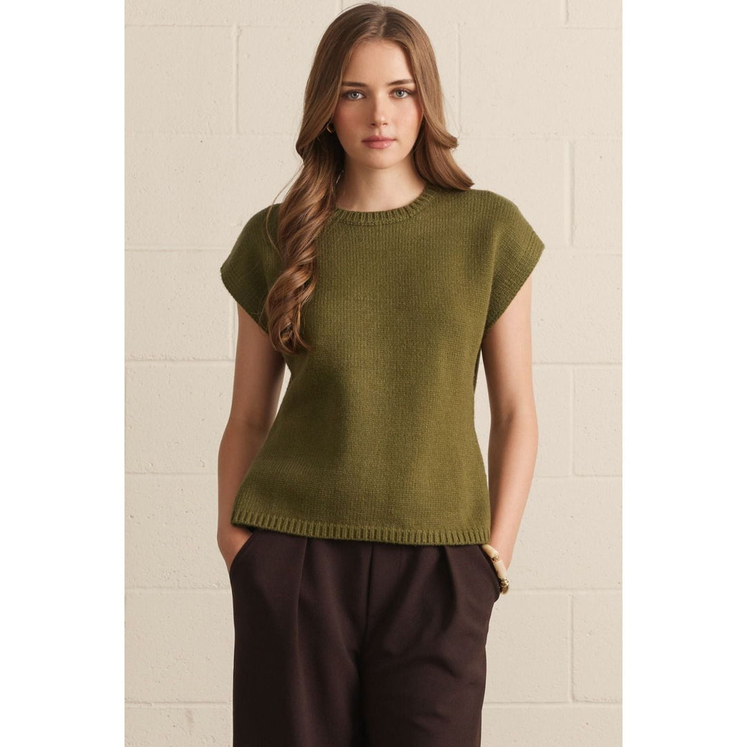 Model wearing The Pearl Pagoda olive green lightweight viscose knit sweater with crew neck and relaxed cap sleeves.