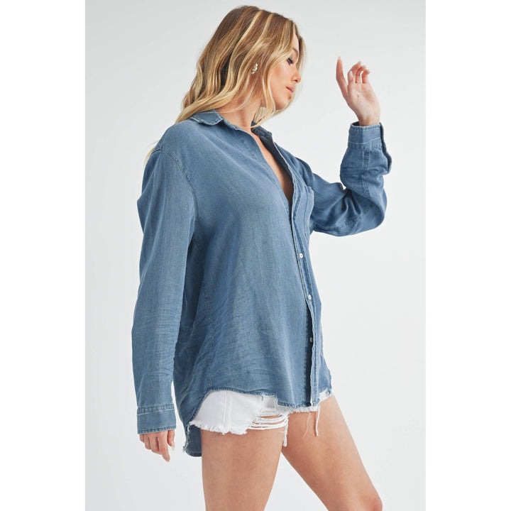 The Pearl Pagoda Ottavia denim top with long sleeves, chest pocket, and raw shirttail hem on a blonde model