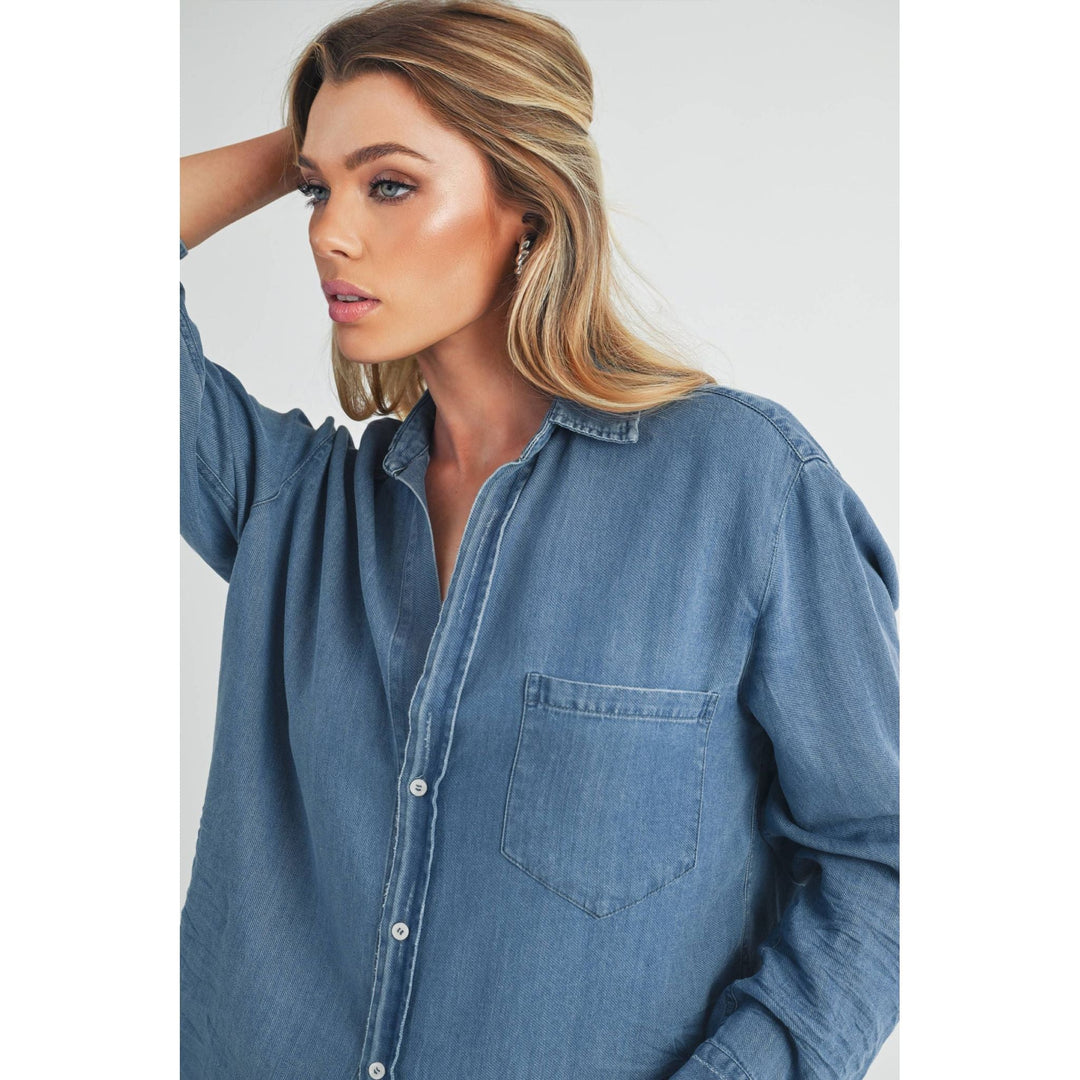 The Pearl Pagoda Ottavia denim top featuring a relaxed fit, chest pocket, and button-down front on a blonde model.